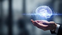 Businessman hand holding glowing digital brain with neural network connections and data waves for artificial intelligence and technology concepts.