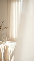 Cozy minimalist interior with soft natural light filtering through sheer curtains, ceramic mug and eucalyptus branch on textured table for home decor.