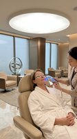 Professional skincare treatment session with female client receiving facial therapy from aesthetician in modern medical spa clinic.