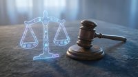 Wooden judge gavel with glowing digital scales of justice hologram on dark surface representing legal technology and modern courtroom innovation.