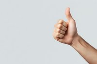 Caucasian hand showing thumbs up gesture against light gray background, expressing positivity, approval, and success in minimal composition.