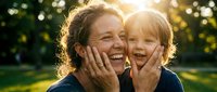 Joyful Caucasian mother and young daughter laughing together outdoors in golden sunlight, showing pure happiness and family bonding moments for parenting content.