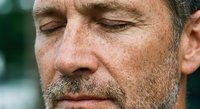 Middle-aged Caucasian man with beard and mustache showing facial wrinkles and aging skin in close-up portrait for skincare and wellness concepts.