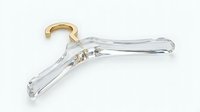 Elegant transparent acrylic clothes hanger with gold hook on light background, luxury wardrobe accessory for fashion and retail design.