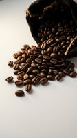 Roasted coffee beans spilling from burlap sack on white background, suitable for cafe, restaurant, and beverage packaging designs.