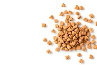 Scattered butterscotch baking chips on white background, isolated food ingredient pattern with copy space for dessert and confectionery designs.