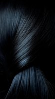 Silky black hair strands with blue highlights flowing in elegant curves against dark background, creating dramatic contrast and shine for beauty and fashion concepts.