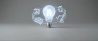 Glowing light bulb with floating innovation icons representing creativity, brainstorming and business solutions on gray background for presentations.