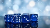 Five blue translucent dice with white dots arranged in a row on reflective surface with bokeh background, suitable for gaming, gambling, and chance-related designs.