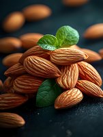 Fresh raw almonds with green mint leaves arranged on dark background with water drops, macro food photography for healthy snack advertising.