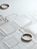 Clear acrylic templates and copper rings on white surface for crafting and design projects. Modern minimalist workspace setup for creative professionals.