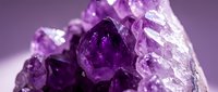 Purple amethyst crystal cluster with natural geometric formations and translucent faceted surfaces on gradient background for healing and wellness designs.