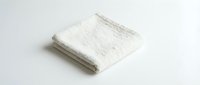 Soft white folded terry towel isolated on white background, perfect for spa, bathroom, and hotel concepts in clean minimal style.