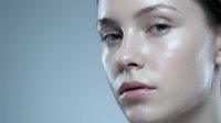 Young Caucasian woman with glowing dewy skin and natural makeup showcasing skincare routine and beauty treatment results for cosmetic advertising.