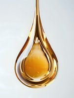Golden liquid drop suspended in mid-air against white background, showing viscous honey-like texture and reflective surface with smooth flowing curves.