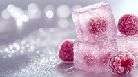 Frozen raspberries in ice cubes on shimmering silver surface with bokeh background, creating elegant dessert garnish for cocktails or beverages.