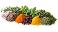 Aromatic herbs and vibrant spices arranged in colorful piles including turmeric, pink salt, black peppercorns, dried basil, thyme and oregano on white background.