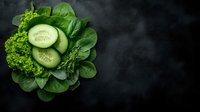 Fresh green vegetables and cucumber slices arranged on dark slate background with copy space for healthy eating and nutrition concepts.