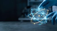 Scientist in blue gloves holding glowing atomic structure with orbiting electrons and particles in laboratory setting for research and innovation concepts.
