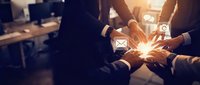 Group of diverse professionals joining hands around glowing envelope icon, symbolizing teamwork, communication, and email collaboration in modern workplace environment.