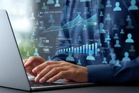 Business professional analyzing financial data on laptop with holographic charts and graphs displaying growth metrics and analytics interface.