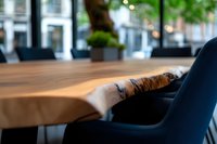 Modern wooden table edge with natural live bark detail in upscale restaurant setting, soft bokeh background shows elegant dining atmosphere.