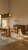 Modern dining room interior with golden pendant lights, wooden furniture, glass table and golden retriever dog sitting on area rug in warm neutral tones.