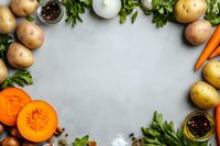 Fresh vegetables frame with pumpkin slices, potatoes, carrots, parsley and spices on gray concrete background, copy space for recipe or menu.