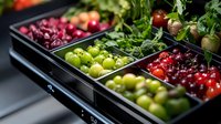 Fresh colorful produce displayed in modern black containers at grocery store, including green apples, red cherries, and cranberries arranged in neat rows.
