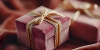 Elegant burgundy gift boxes with golden ribbons on luxurious silk fabric, perfect for holiday celebrations, special occasions and festive presentations.
