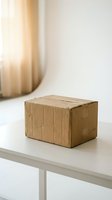 Cardboard package box on white table in bright modern interior with natural sunlight for delivery and shipping services.