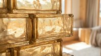 Stacked golden glass blocks with textured surfaces casting warm light, suitable for interior design, architecture, and modern decor projects.
