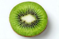 Fresh kiwi fruit slice showing vibrant green flesh and black seeds in circular pattern isolated on white background for healthy food designs.