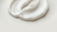 Smooth white cream swirl on neutral background for skincare cosmetics and beauty product applications in advertising and packaging design.