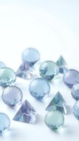 Colorful glass spheres and geometric crystals scattered on white surface creating elegant decorative composition for luxury design projects.
