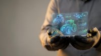 Businessman holding holographic display showing agricultural tractors and farm machinery with digital interface elements for modern farming technology concepts.