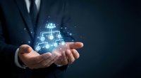 Businessman holding glowing digital network connections with people icons in cupped hands representing teamwork and professional collaboration concepts.