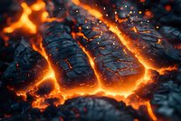Glowing hot lava cracks through dark volcanic rock surface, creating dramatic pattern of molten magma streams with bright orange light and floating embers.