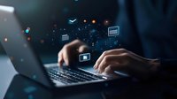 Hands typing on laptop keyboard with digital icons floating, representing online banking and financial technology services in dark blue atmosphere.