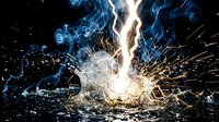 Dramatic welding sparks and blue flames creating intense industrial metalwork scene with bright orange sparks flying against dark background for manufacturing concepts.