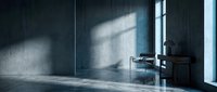 Minimalist dark interior room with concrete walls and natural window light creating dramatic shadows on floor for modern architectural design projects.