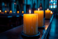 Glowing candles in church interior create peaceful atmosphere for prayer and meditation with warm light and spiritual ambiance for worship services.