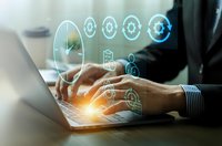 Professional businessman typing on laptop with glowing digital security icons and network connections overlay representing cybersecurity technology solutions.