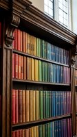 Ornate wooden bookshelf with colorful rainbow-arranged vintage books in elegant library interior with natural window light for academic and literary themes.