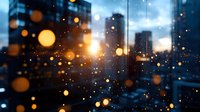 Moody urban cityscape with glowing bokeh lights and raindrops on window glass creating dreamy atmosphere during blue hour. Defocused city buildings in background.