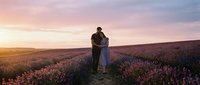 Couple embracing in blooming lavender field at sunset, romantic engagement or wedding moment in nature landscape.