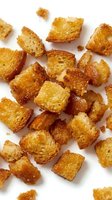 Crispy golden croutons scattered on white background, ready for salads, soups, and culinary designs.