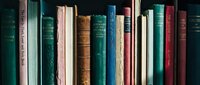 Vintage books collection with colorful spines arranged on bookshelf. Classic literature library display for education, reading and knowledge concepts.