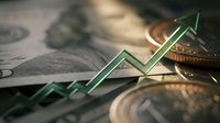 Financial growth concept with green arrow trending upward over dollar bills and coins representing investment success and economic prosperity.