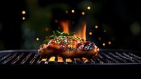 Juicy grilled chicken breast with honey glaze and herbs on barbecue grill with fire flames and bokeh lights in dark atmospheric background.